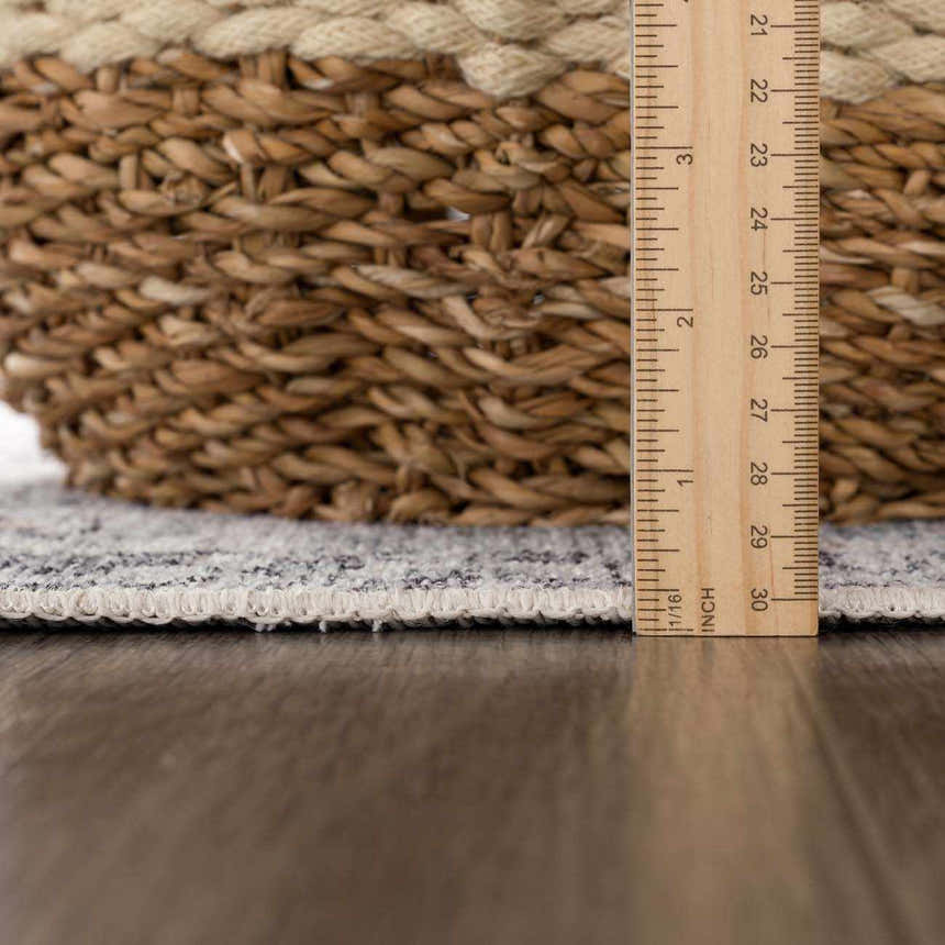 Close-up of Light Blue Holi-4603 rug edge with ruler and woven basket, showing texture and pile height. Pile