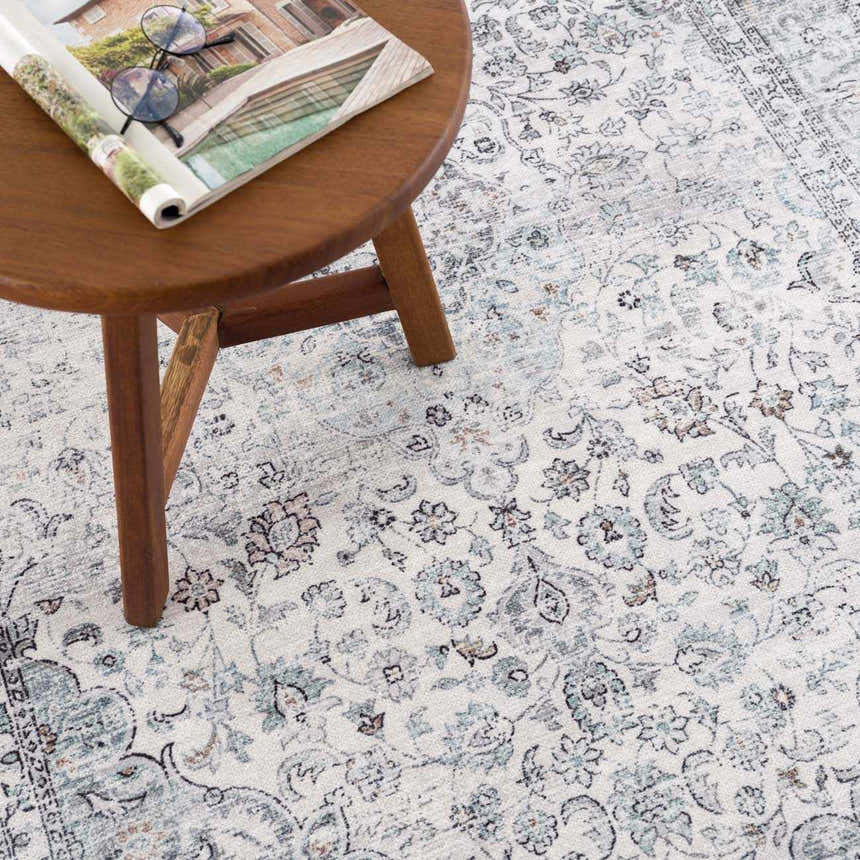 Close-up of the Light Blue Holi-4603 Washable Area Rug, featuring a traditional floral pattern in light blue, gray, and off-white. Styleshot