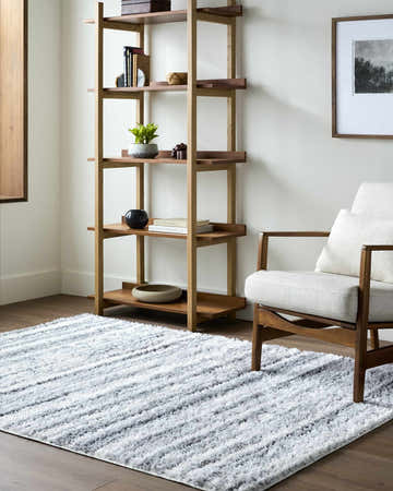 Living room scene with a cream chair and Blaise Area Rug in cream and gray. Contemporary style. Roomscene-Rectangle