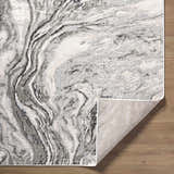Close-up of the Brandi Gray Marble Area Rug featuring beige, cream, and gray marble-like design and folded corner. Fold