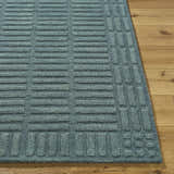 Close-up of the hand-tufted Birger Slate Blue Area Rug. Features a contemporary geometric design and 100% wool texture. Front