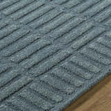 Close-up of the Birger Slate Blue Area Rug. Hand-tufted, 100% wool rug with a geometric, textured design in slate blue and steel gray. Texture
