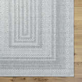 Close up of the Bernal Area Rug in medium gray and white with a geometric pattern. Corner