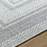 Close-up of the Bernal Area Rug. Gray and white woven rug with a geometric, farmhouse-style pattern. Texture