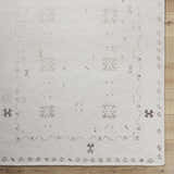 Close up of the ivory Bhavna Area Rug showing the hand tufted texture and sandstone geometric pattern. Corner