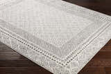 Close up of the Livabliss Bahar BHR-2321 area rug. Off white rug with a charcoal geometric and floral pattern. Corner