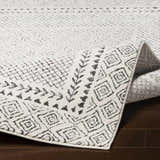 Close-up of the Livabliss Bahar BHR-2321 area rug, showing its charcoal and off-white geometric pattern and machine-woven texture. Fold