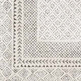 Close-up of the Livabliss Bahar BHR-2321 area rug. Features a charcoal and off-white geometric pattern and machine woven texture. Swatch