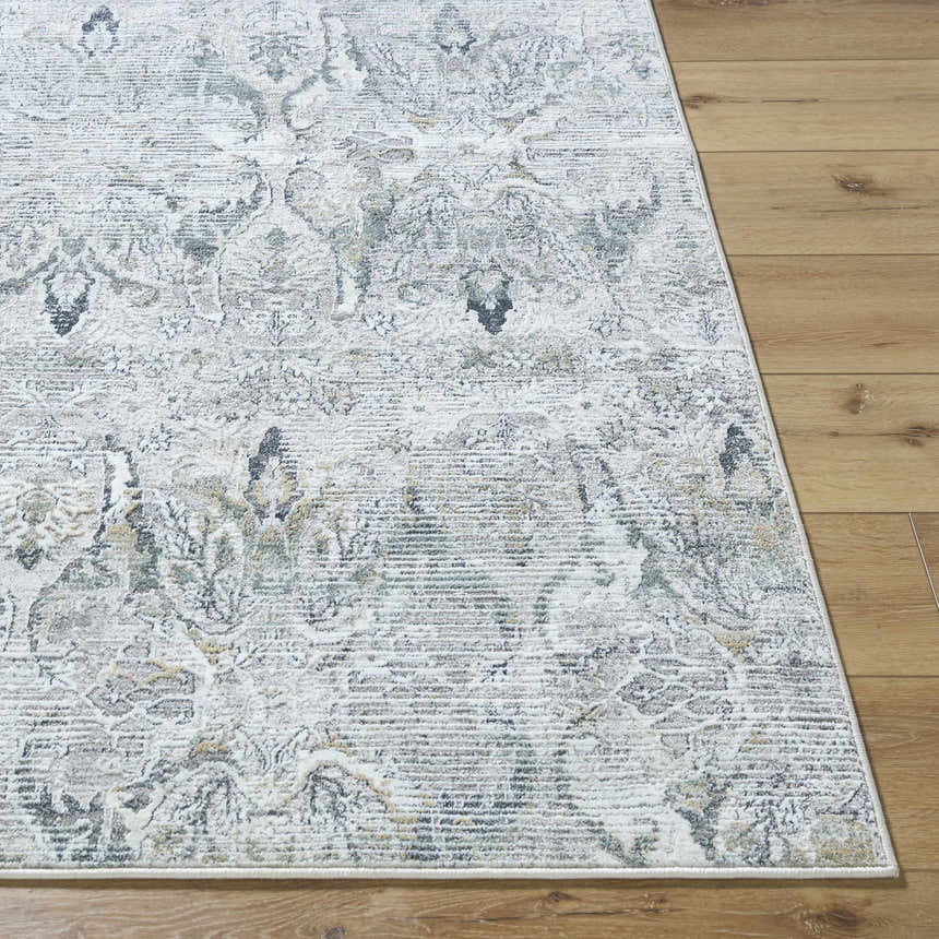 Close-up of the Bryony Area Rug. Traditional farmhouse design in light silver, silver gray, and slate blue on wood floor. Front