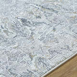 Close-up of the Bryony Area Rug. Farmhouse style rug in light silver, silver gray, and slate blue with traditional pattern. Texture