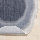 Close-up of the machine-woven Burian Blue Area Rug showing its blue, cream, and navy farmhouse-style pattern and texture. Fold