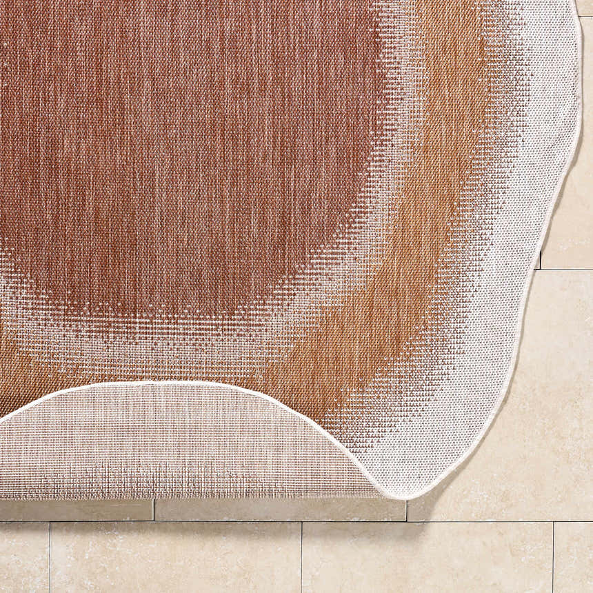 Close-up of the Burian Orange Area Rug showing burnt orange, cream, and rust colors and machine-woven texture. Fold