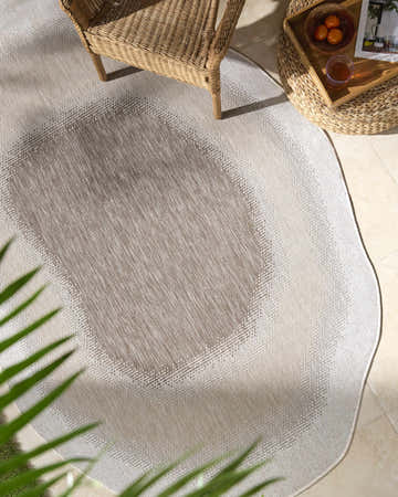 Overhead shot of a cream and brown Burian Brown Area Rug in a sunlit indoor patio setting. Roomscene-Custom