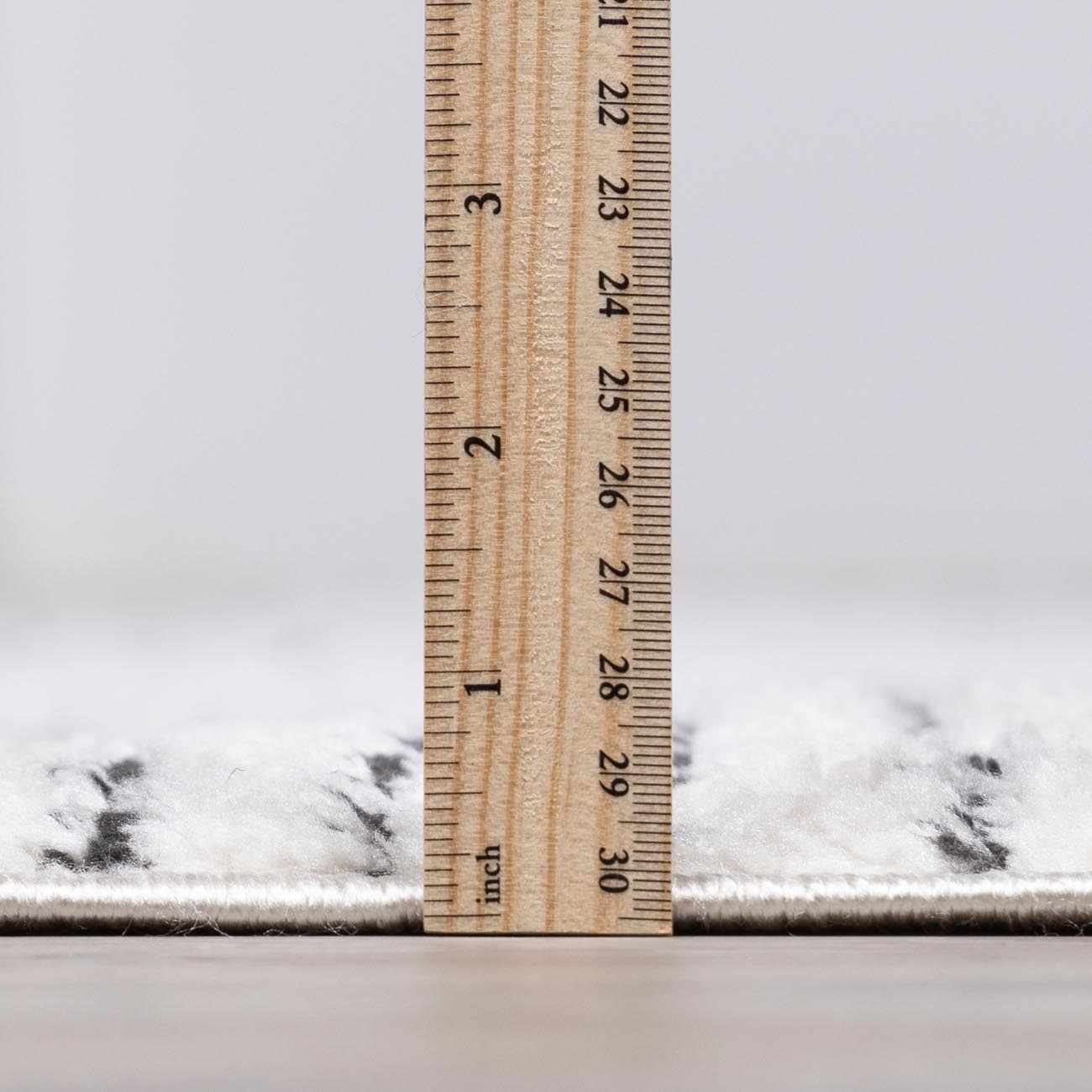 Close-up of the Modern Scandi Architect I Area Rug showing the high pile and thickness with a ruler. Pile