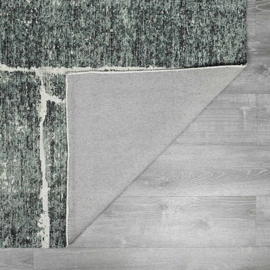Close-up of the Janek II Modern Abstract Area Rug showing its green, black, and white abstract design and hand-tufted texture. Fold