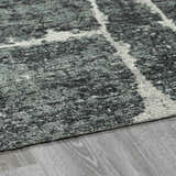Close-up of the Janek II Modern Abstract Area Rug. Hand-tufted polyester rug with a gray, black, and white geometric pattern. Pile