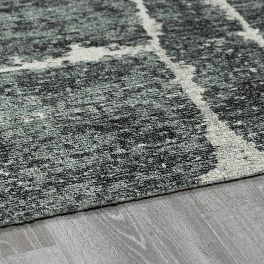 Close-up of the Janek II Modern Abstract Area Rug. Hand-tufted polyester rug with a gray, black, and white geometric pattern. Pile