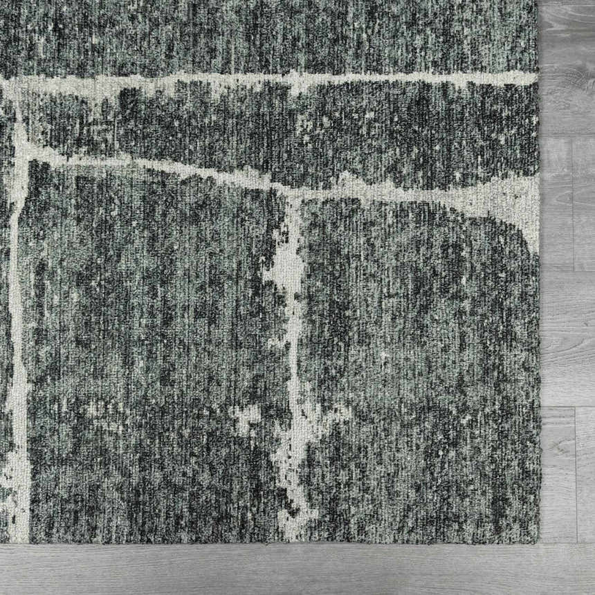 Close-up of the Janek II Modern Abstract Area Rug. Hand-tufted polyester rug in shades of gray with a white abstract pattern. Swatch