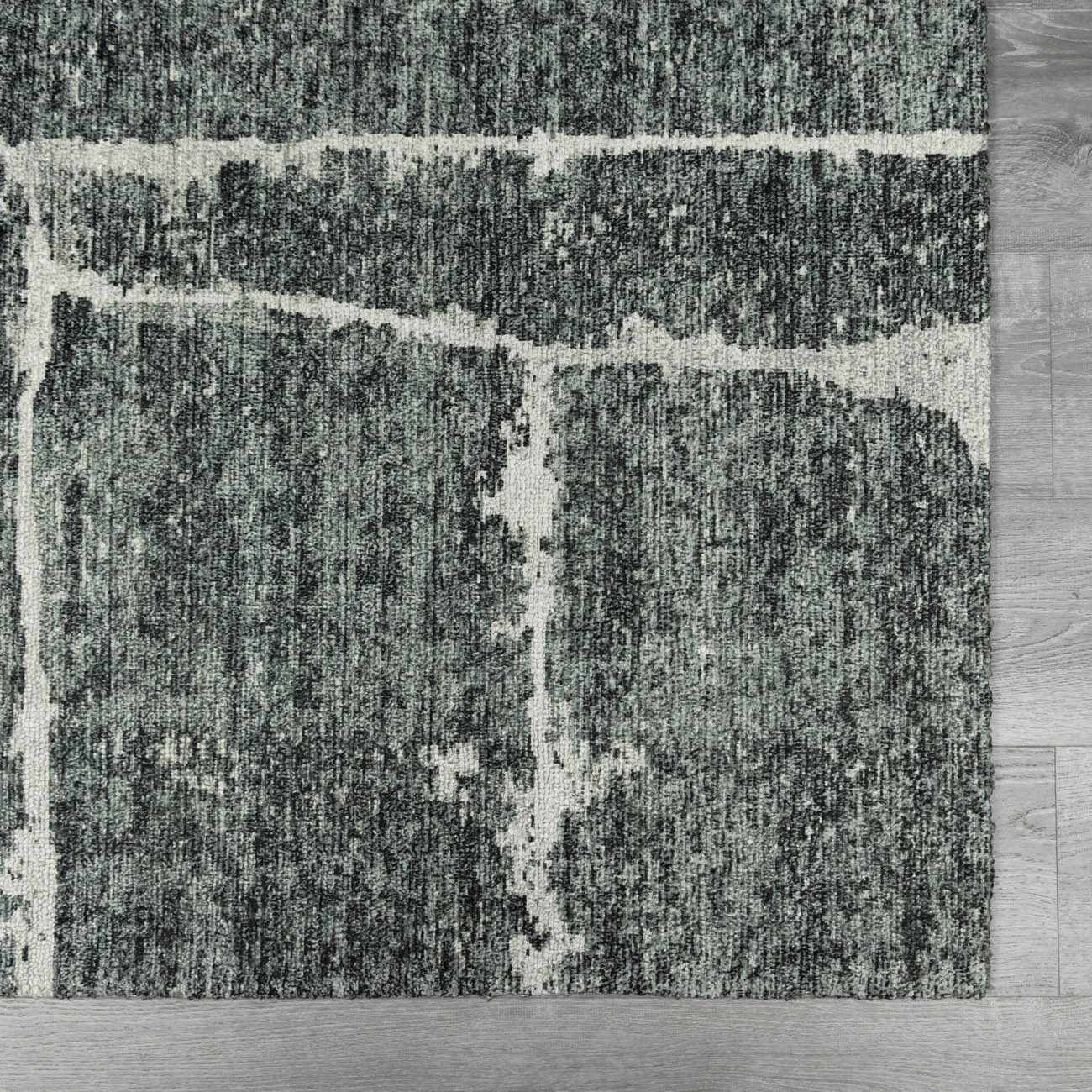 Close-up of the Janek II Modern Abstract Area Rug. Hand-tufted polyester rug in shades of gray with a white abstract pattern. Swatch