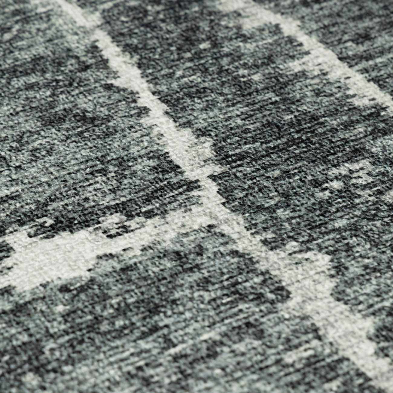 Close-up of the Janek II Modern Abstract Area Rug. Hand-tufted polyester rug with a black, gray, and white geometric pattern. Texture