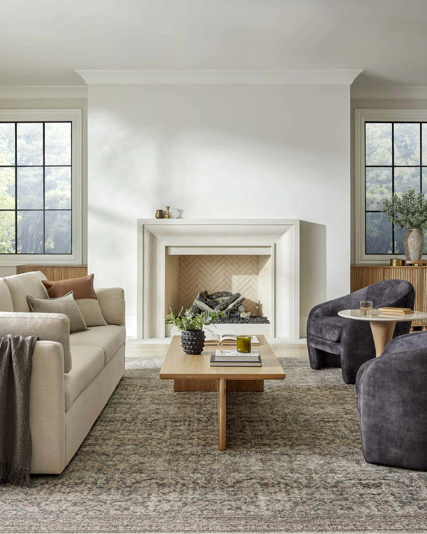 Living room with fireplace and beige sofa styled with the Collins Avenue III Vintage Damask Area Rug. Roomscene-Rectangle
