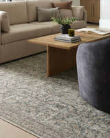 Living room scene with a beige sofa and the Collins Avenue III Vintage Damask Area Rug in beige, red, and green. Styleshot