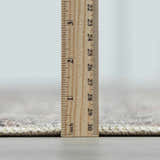 Close-up of the Collins Avenue III Vintage Damask Area Rug showing its pile height with a ruler. Beige, red, green, and ivory colors. Pile