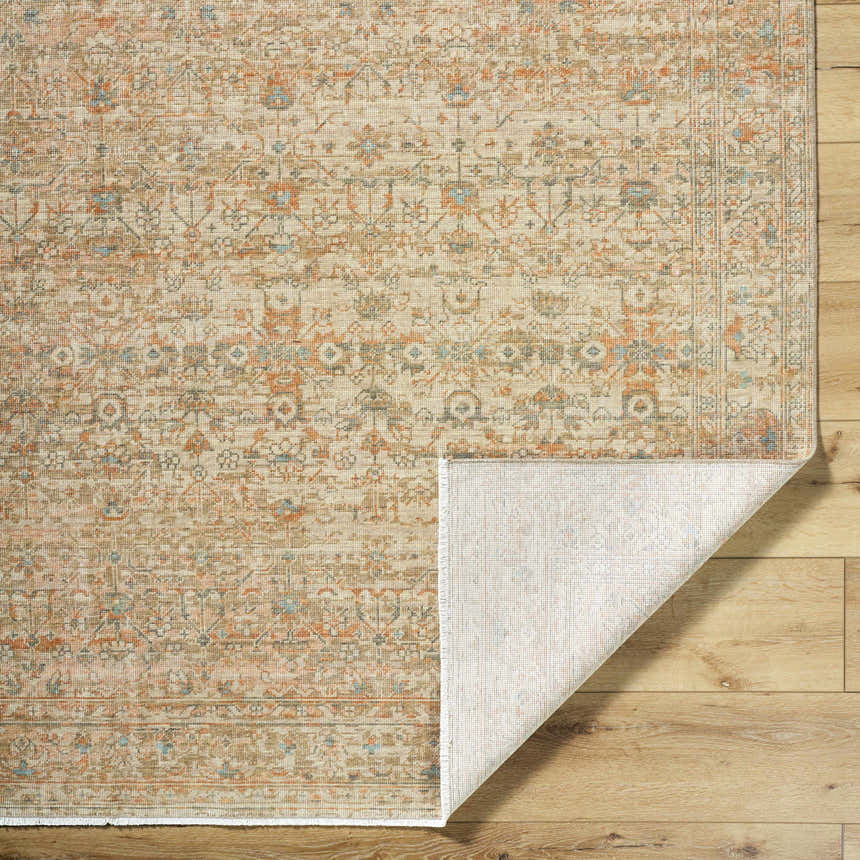 Close-up of Becki Denim Owens x Livabliss Renaissance Area Rug showing beige, coral, and denim traditional pattern and wool texture. Fold
