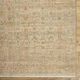 Close-up of the Becki Denim Owens x Livabliss Renaissance Area Rug. Beige, denim, coral, and tan farmhouse-style wool rug. Corner