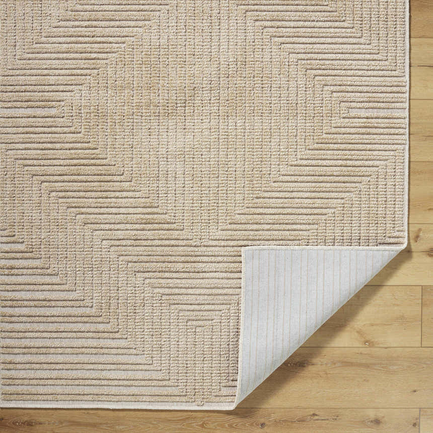 Close-up of the Briana Brown Washable Area Rug, showcasing its beige geometric pattern and machine-woven texture on wood floor. Fold