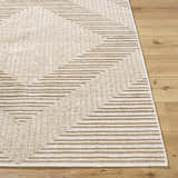Close up of the Briana Brown Washable Area Rug, showing a geometric pattern in beige and light brown on wood floor. Front