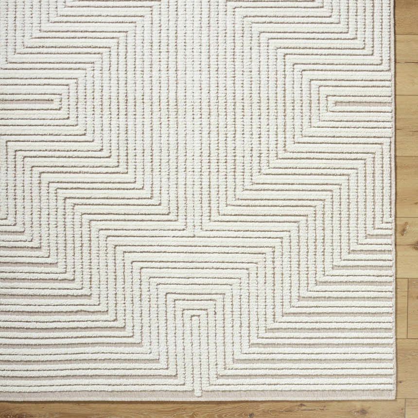 Close up of the Briana Beige Washable Area Rug. Beige and off-white geometric design with a textured, machine-woven construction. Corner