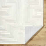 Close-up of Briana Off-White Washable Area Rug showing geometric design, plush texture, and non-slip backing on wood floor. Fold