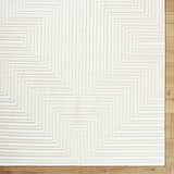 Close-up of the Briana Off-White Washable Area Rug, showing a geometric maze pattern and soft, textured pile. Corner