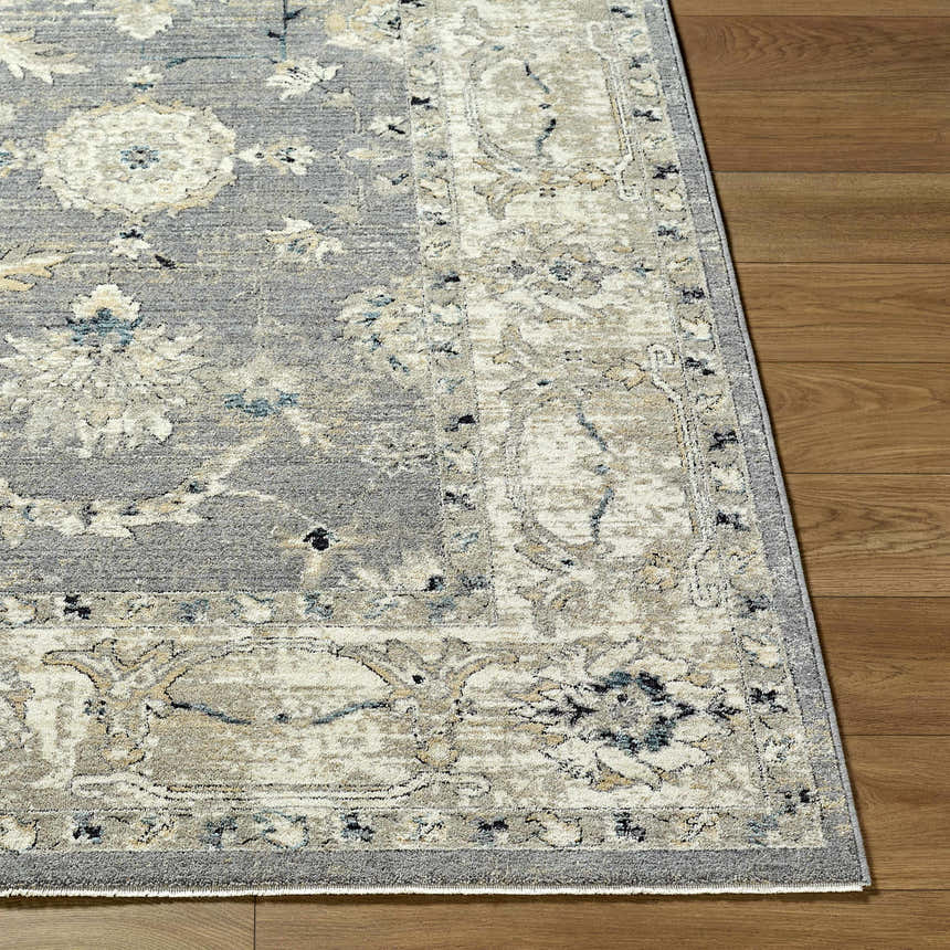 Close-up of the Noci Ivory Persian rug showing its beige, gray, ivory, and teal floral pattern and machine-woven texture. Front