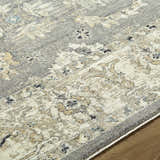 Close-up of the Noci Ivory Persian rug. Machine woven polyester with beige, gray, and teal floral pattern. Texture