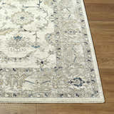 Close up of the Yume Ivory Persian rug showing its charcoal, olive, and slate blue floral pattern and soft texture. Front