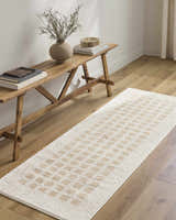 Hallway scene with a Baback Beige Washable Area Rug, wood floors, and a rustic wood bench with books and a vase. Roomscene-Runner