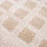 Close-up of the Baback Beige Washable Area Rug, showing a textured, geometric diamond pattern in beige and peach tones. Texture