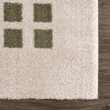 Close up of the plush Baback Green Washable Area Rug with a geometric green square pattern. Swatch