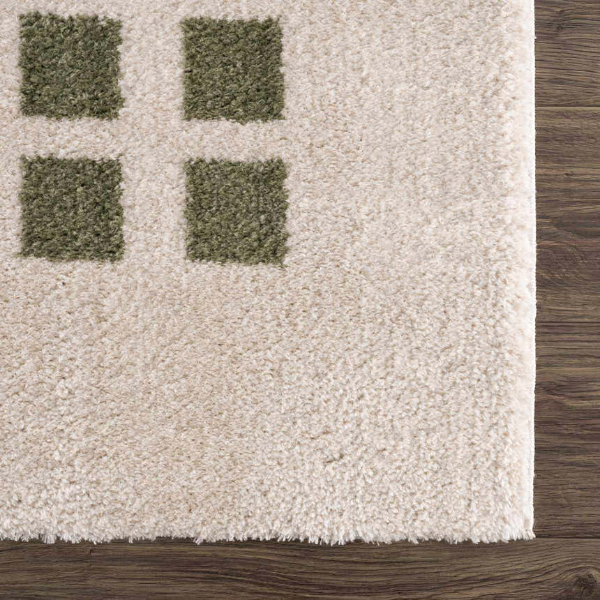 Close up of the plush Baback Green Washable Area Rug with a geometric green square pattern. Swatch