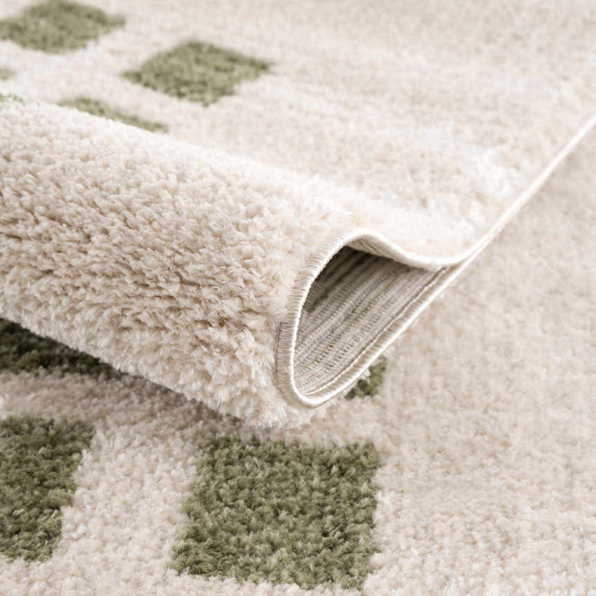 Close-up of the Baback Green Washable Area Rug showing lime green squares on a plush, cream-colored polyester rug. Fold