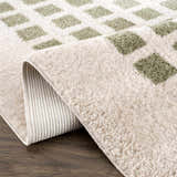 Close up of the Baback Green Washable Area Rug showing its lime green square pattern and soft, textured pile. Fold