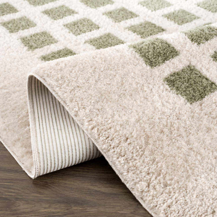 Close up of the Baback Green Washable Area Rug showing its lime green square pattern and soft, textured pile. Fold
