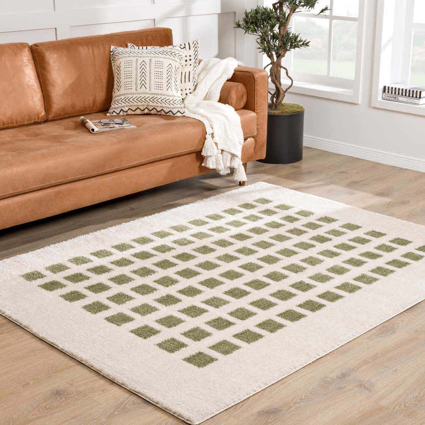 Living room with tan leather sofa and Baback Green Washable Area Rug with a geometric diamond pattern. Roomscene-Rectangle