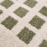 Close-up of the Baback Green Washable Area Rug, showing a lime green diamond pattern on a cream-colored, textured background. Texture