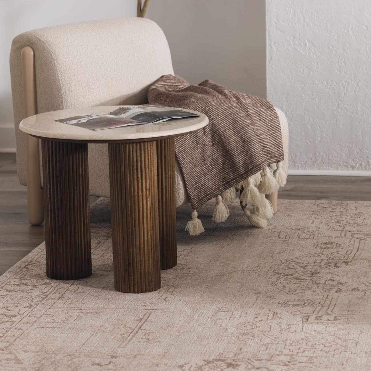 Living room scene with a Galey Alix Collins Avenue V Vintage Medallion Rug in beige and dark red under a side table. Styleshot