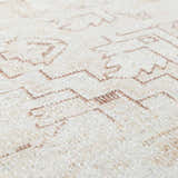 Close-up of Galey Alix Collins Avenue V Vintage Medallion Rug. Beige rug with dark red geometric pattern and soft texture. Texture