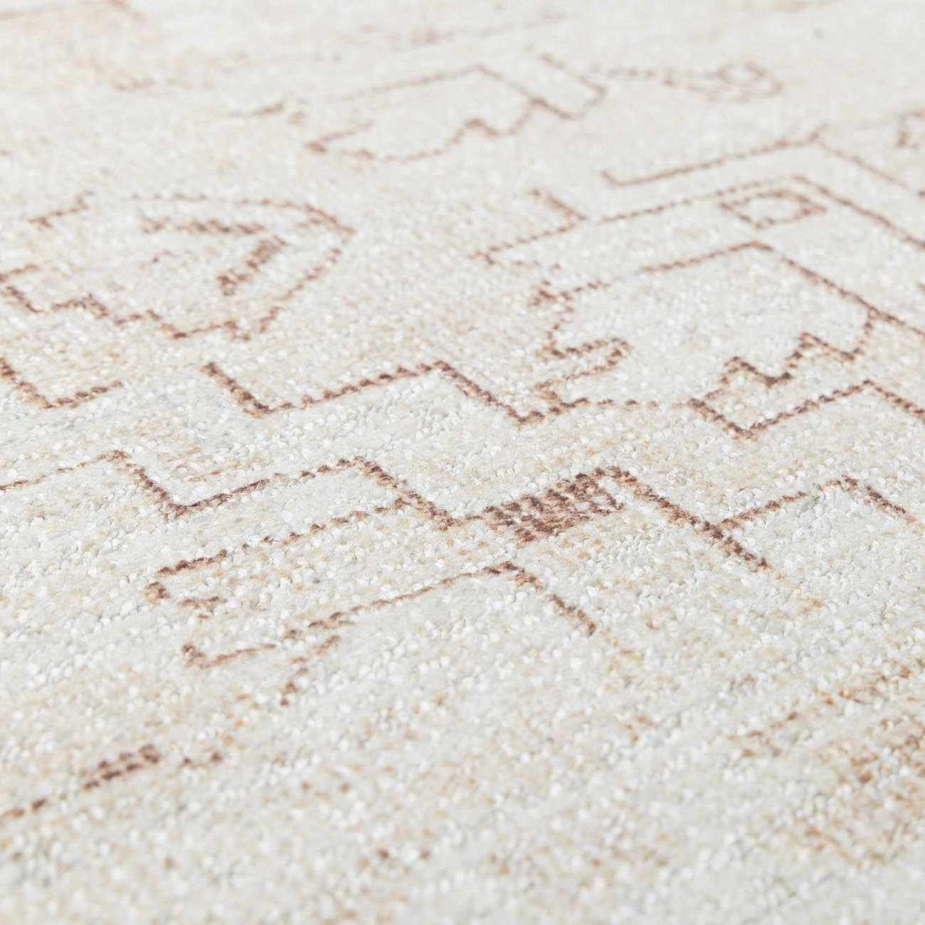Close-up of Galey Alix Collins Avenue V Vintage Medallion Rug. Beige rug with dark red geometric pattern and soft texture. Texture