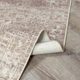 Close-up of the Galey Alix Collins Avenue VI Vintage Medallion Rug. Dark brown and ivory traditional rug with a distressed medallion pattern. Fold
